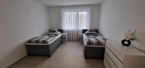 a small room with two beds and a window at Boxspring Apartment Rottweil mit Stellplatz in Rottweil