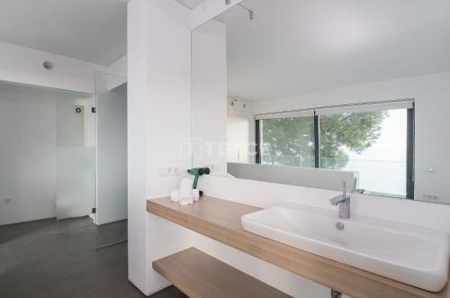a white bathroom with a sink and a window at TEKCE Villa Faralya N131 in Kızılcakaya