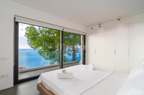 a bedroom with a large window and a large bed at TEKCE Villa Faralya N131 in Kızılcakaya