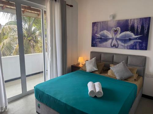 a bedroom with a bed with two towels on it at Danish Crown Hotel in Ambalangoda