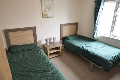 a bedroom with two beds and a window at Shrimp Shack in Heysham