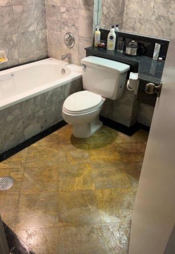 a bathroom with a white toilet and a bath tub at Suvannee guesthouse in Ban Khlong Hua Sakae