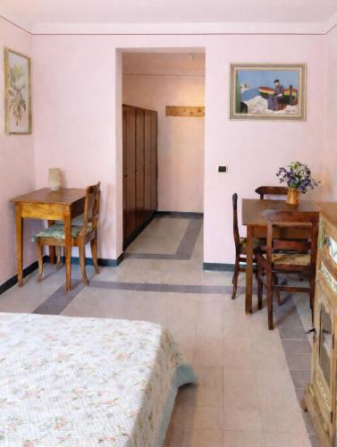 a room with a bed and a table and chairs at Casa Rosa - monolocale con giardino e posto auto in Levanto