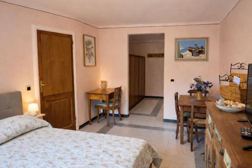 a bedroom with a bed and a table and chairs at Casa Rosa - monolocale con giardino e posto auto in Levanto