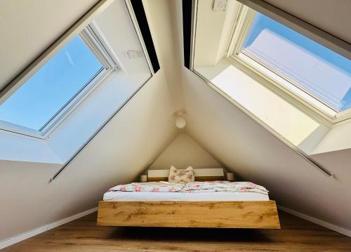 a bed in a room with three windows at Ferienwohnung Storchennest Vipperow in Ludorf