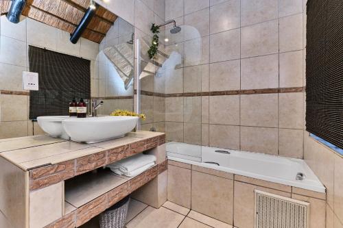 a bathroom with a sink and a tub at Jewel On Juweel in Four Ways