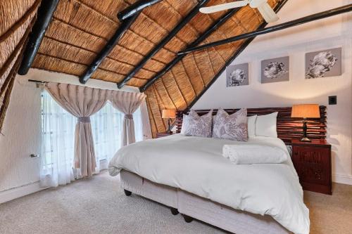 a bedroom with a large bed and a wooden ceiling at Jewel On Juweel in Four Ways