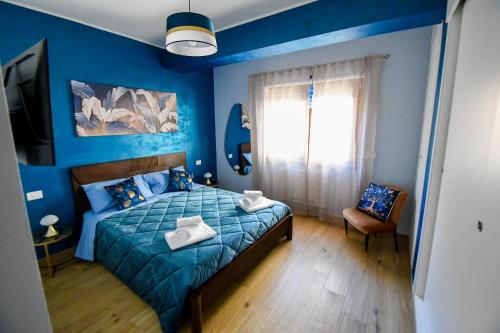 a blue bedroom with a bed and a chair at B&B Maison Glenì in Isernia