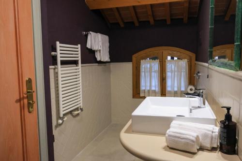 a bathroom with a white sink and a mirror at The Tower in Torreglia