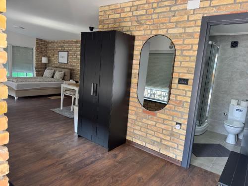 a bathroom with a brick wall and a mirror at Apartmani Petra Bezdan in Bezdan
