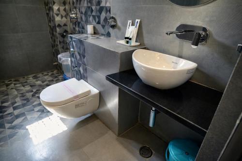 a bathroom with a white toilet and a sink at Tulsi Resort in Gorakhpur