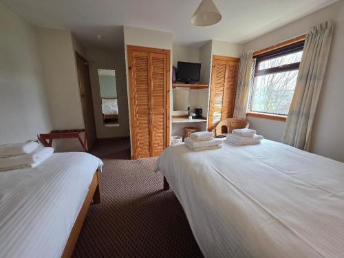 a hotel room with two beds and a window at Peedie Sea Accommodation in Orkney