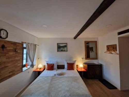 a bedroom with two beds and a clock on the wall at Slovenian House Vida in Bled