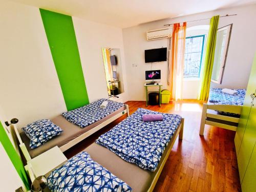 a room with three beds and a green wall at Croparadise Central in Split