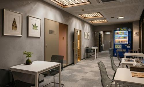 a waiting room with tables and chairs in an office at 心斎橋難波関空直通 Ambers Hostel in Osaka