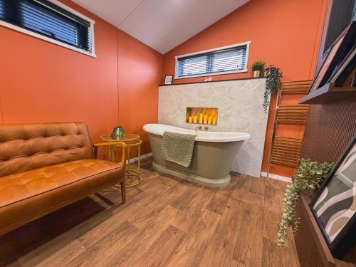 a bathroom with a bath tub and a fireplace at Honeysuckle Lodge in Bassenthwaite