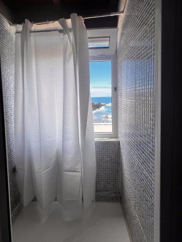 a bathroom with a shower with a view of the ocean at Paradise in El Cotillo in El Cotillo