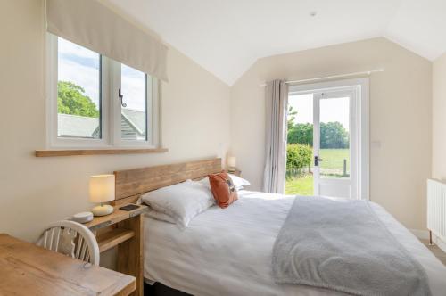 a bedroom with a bed and a table and a window at The Warren in Biddenden