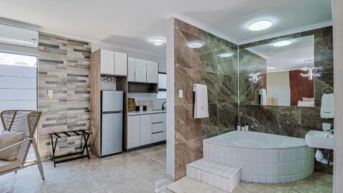 a bathroom with a tub and a sink and a refrigerator at DonDave Guesthouse in Rustenburg
