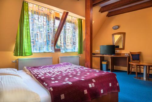 a bedroom with a bed and a table and a window at Relax hotel FIM in Belá