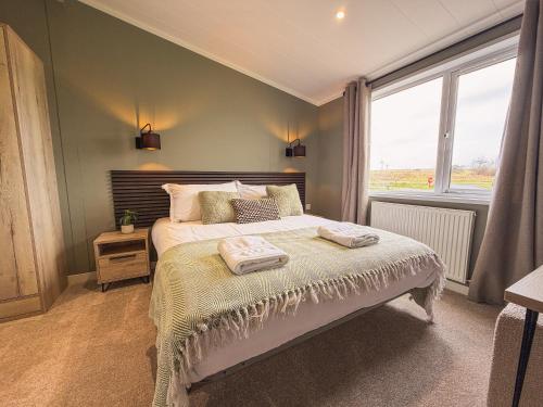 a bedroom with a bed and a large window at Sycamore Lodge in Bassenthwaite