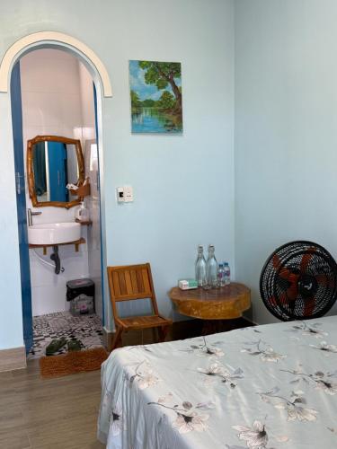 a bedroom with a bed and a sink and a mirror at Homestay JB Sơn Hải in Thôn Sơn Hải