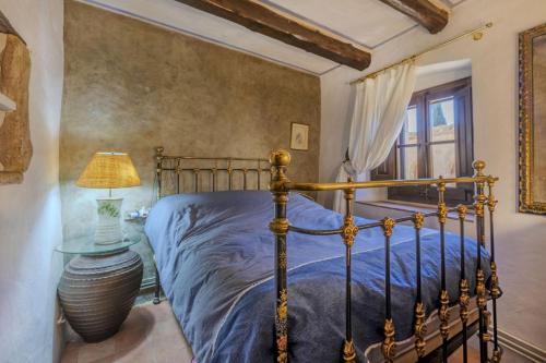 a bedroom with a bed and a lamp on a table at Balco de l' Empordà in Corçà
