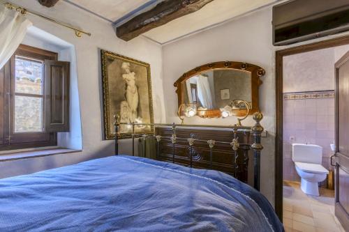 a bedroom with a blue bed and a mirror at Balco de l' Empordà in Corçà