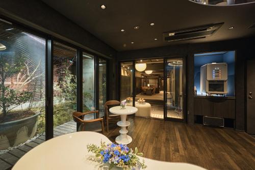 a room with a table and chairs and windows at Wakasa Annex in Nara
