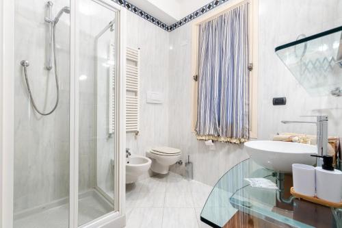 a bathroom with a shower and a sink and a toilet at Hostdomus - Salsedine Apartment in Alassio