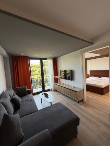 a living room with a couch and a bed at Hotel Apart Odeon in Durrës