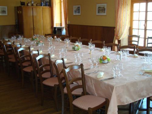 a long table in a room with chairs and wine glasses at L'Hotel du Nord - Quarré-les-Tombes in Quarré-les-Tombes