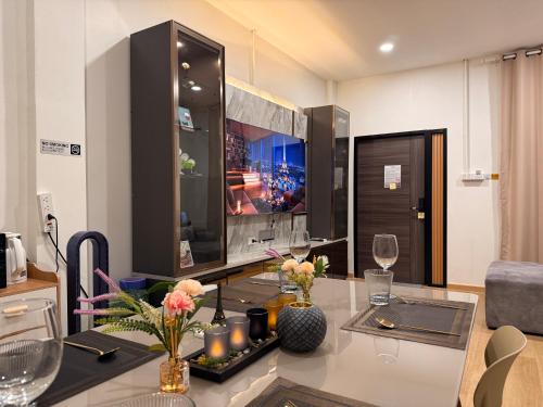 a living room with a table with candles and a tv at Serenova Hotel Siam Paragon, Bangkok in Bangkok