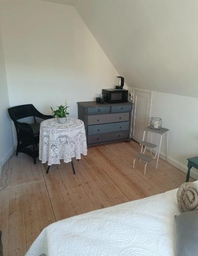 a bedroom with a table and a dresser and a bed at Skøn rolig villa in Dianalund