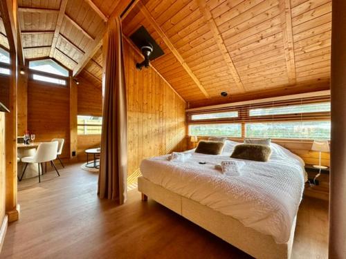 a bedroom with a large bed in a wooden ceiling at Chalet Ivoire in Durbuy