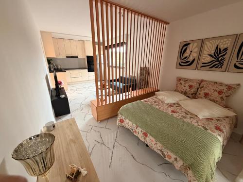 a bedroom with a bed and a table in it at Studio neuf élégant- calme & cosy in Oyonnax