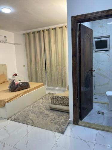 a room with a bed and a shower and a mirror at درة عبين الدور الارضي 2 in ‘Ibbīn