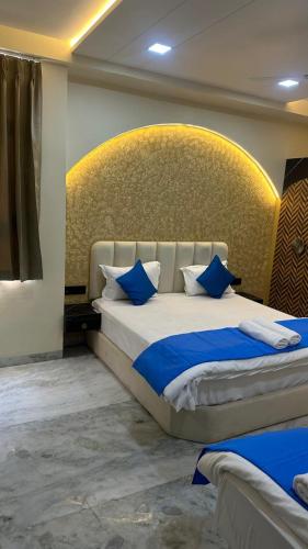 a bedroom with a large bed with blue pillows at KDM Hotel Indore Palace- Newly Renovated 4 Star Premium Hotel in Shirdi