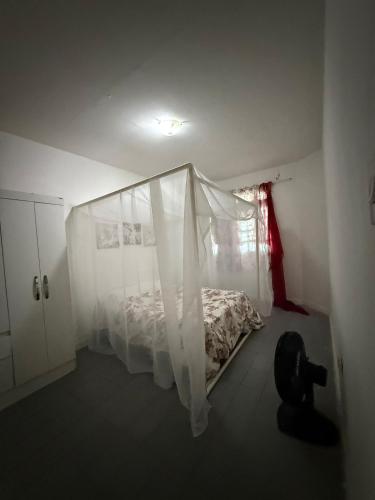 a bedroom with a bed with a mosquito net at Villa Bárbara residência in Aracaju