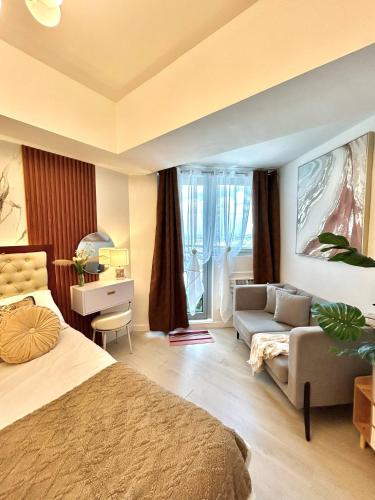 a bedroom with a bed and a couch and a table at Azure Luxe Haven by Irene in San Fernando