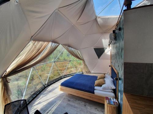 a bedroom in a tent with a bed in it at Glamping Podniebny in Borsk