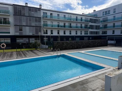 a swimming pool in front of a building at Azores Lava Apartment T3 in Ponta Delgada