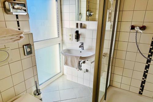 a bathroom with a shower and a sink at Hotel Garni Möwe in Tutzing