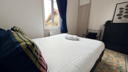 a bedroom with a white bed with a window at Escapade sur la Loire in Nevers