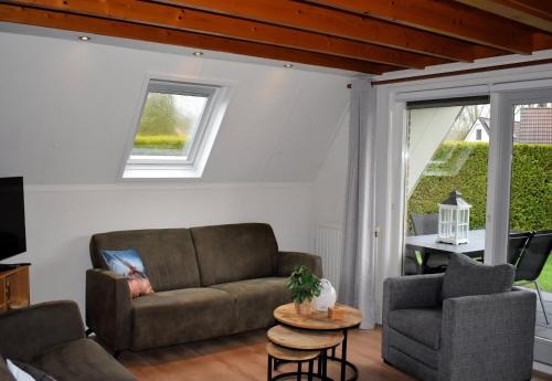 a living room with a couch and a table at Torenvalk I Genieten nabij Bos in Zwiggelte