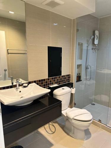 a bathroom with a toilet and a sink and a shower at Marigold Sukhumvit - Free Shuttle to BTS Bearing Station in Bangkok