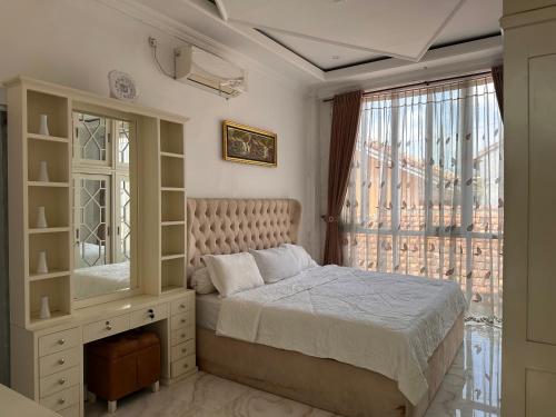 a bedroom with a bed and a large window at RBD Guest House in Ungaran