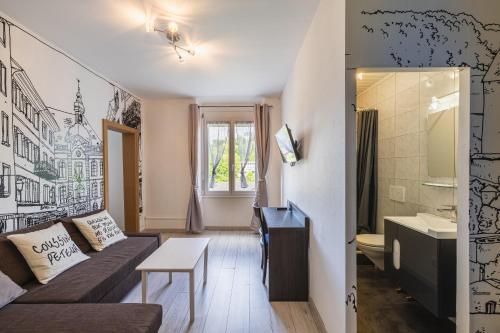 un soggiorno con divano e bagno di Hôtel Terminus a Porrentruy