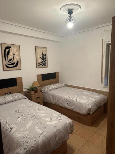 a bedroom with two beds and a ceiling fan at Casa en Laredo in Laredo
