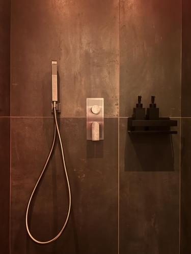 a shower with a hose attached to a wall at Domus Europa in Matera